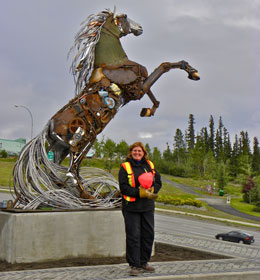 a happy artist in front of the mounted horse sculpture.